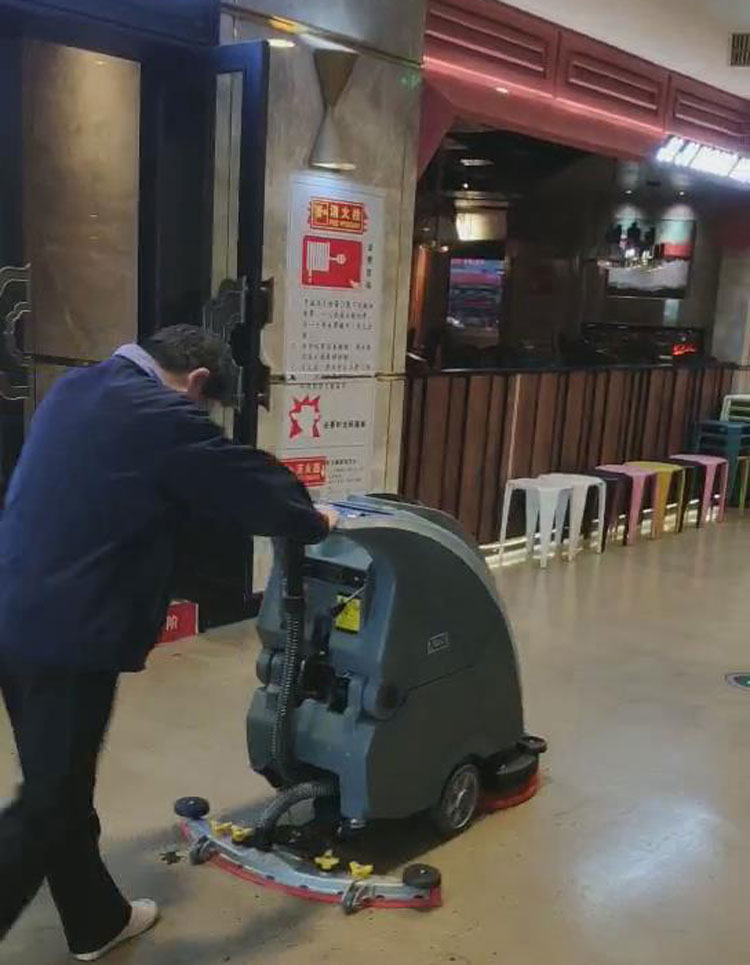 百盛商场的保洁人员对888集团X750手推式洗地机进行独立操作试用
